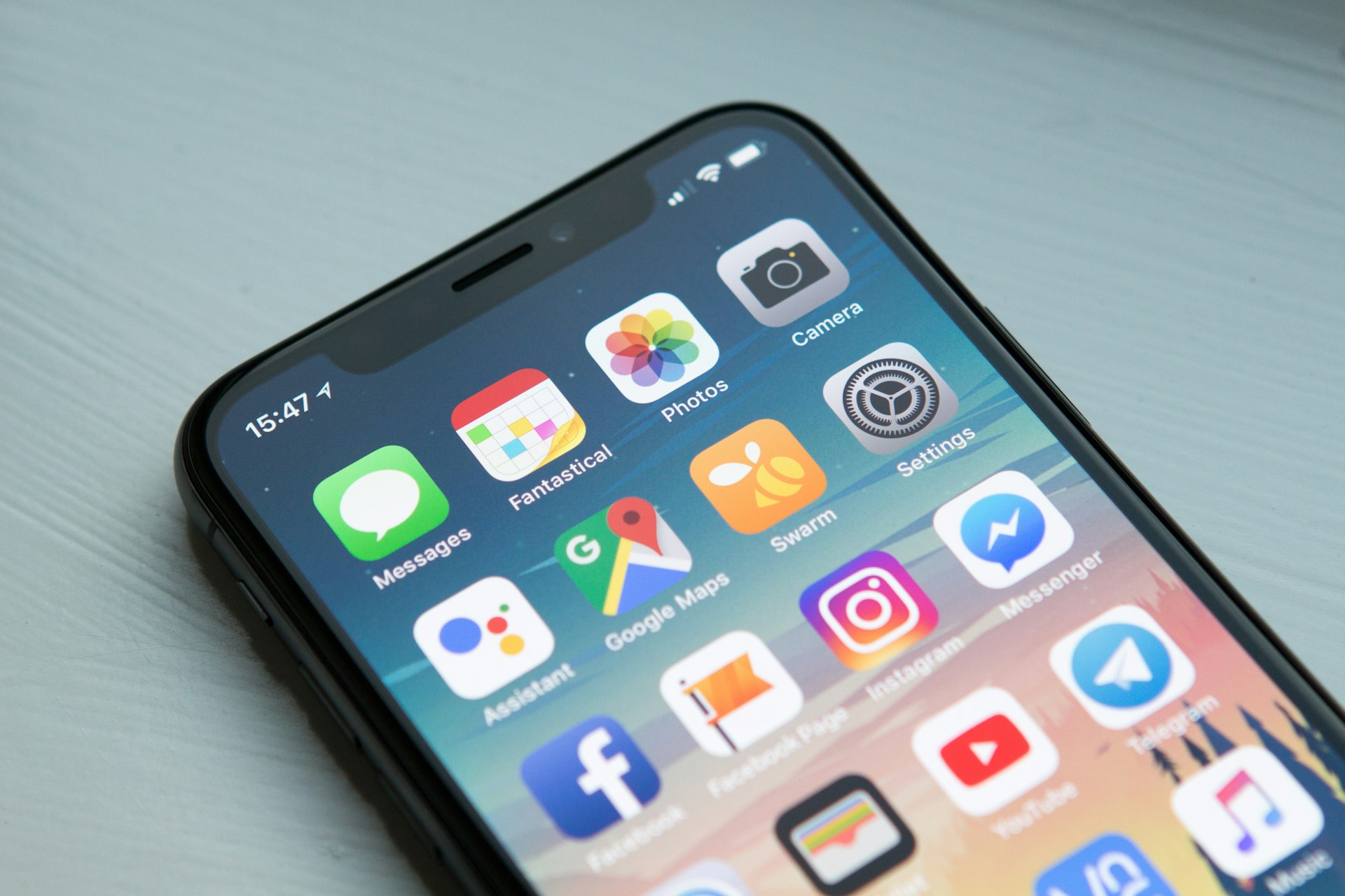 一台 iPhone 显示主屏幕上排布的 App 图标 —— 移动应用即广告 SDK 的投放载体